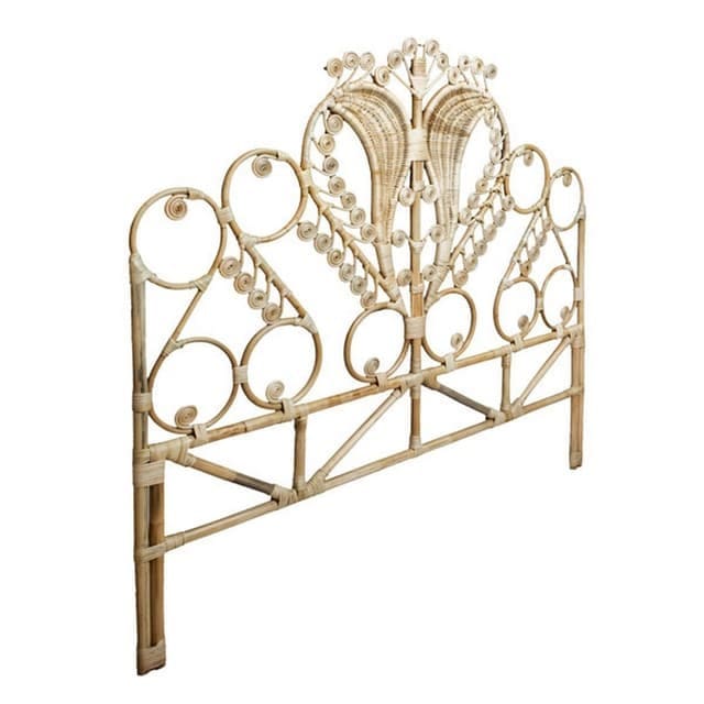 Decorative rattan bed headboard with an ornate swirl design